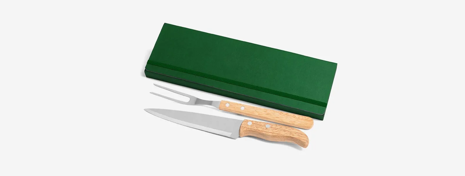 Conjunto composto por uma faca 7” e um garfo trinchante, ambos com cabos em madeira e lâminas em aço Inox. Estão organizados em uma pasta verde com elásticos.