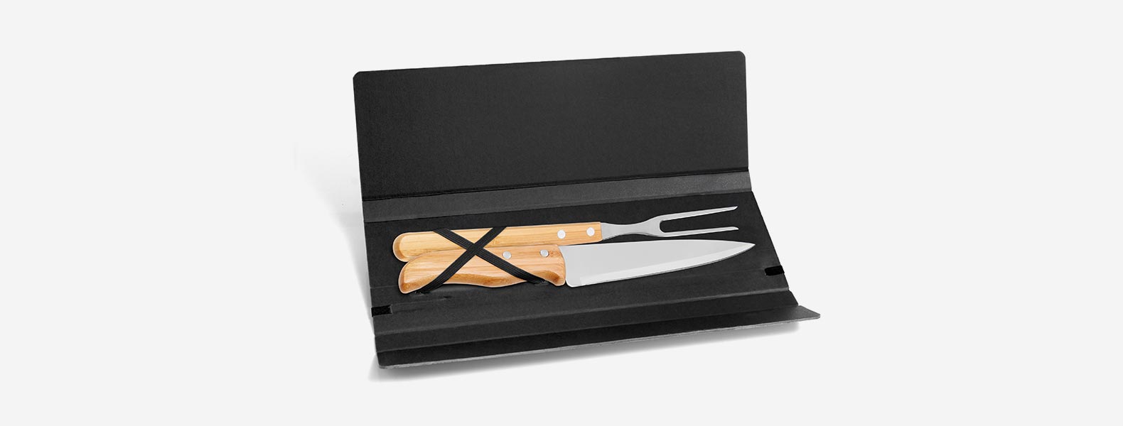 Conjunto composto por uma faca 7” e um garfo trinchante, ambos com cabos em Bambu e lâminas em Aço Inox com rebites resistentes. Estão organizados em uma pasta preta com elásticos.