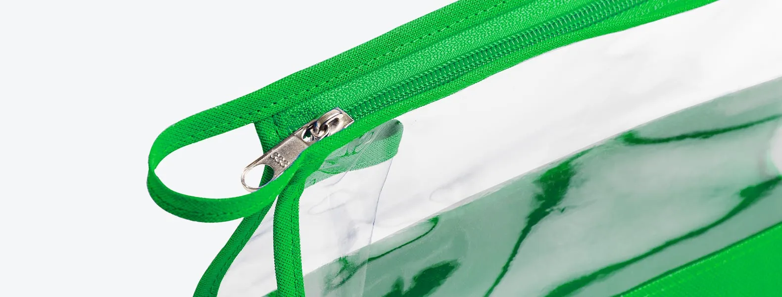 Necessaire na cor verde transparente confeccionada em PVC / Nylon 600. Conta com fechamento em zíper e alça. Disponível nas cores preta, azul, vermelha e verde.
