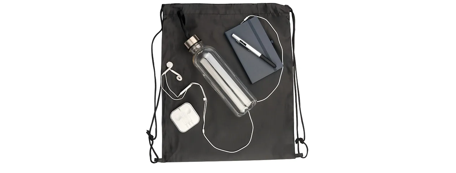 Kit boas vindas. Conta com mochila sacola preta em nylon 210D, caderno para anotações cinza com capa dura, garrafa transparente em PET, fone de ouvido e caneta esferográfica em ABS prata.