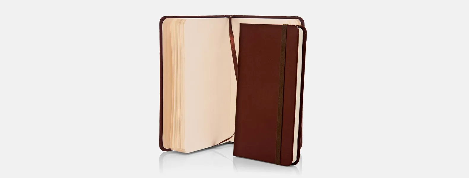 Caderno para anotações marrom com capa dura em Courino. Conta com 80 folhas não pautadas e elástico para fechamento. Gramatura da folha de 70 g/m2.