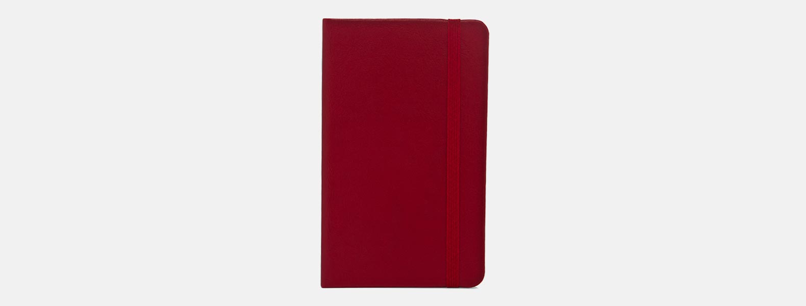 Caderno para anotações vermelho com capa dura em Courino. Conta com 80 folhas não pautadas e elástico para fechamento. Gramatura da folha de 70 g/m2.