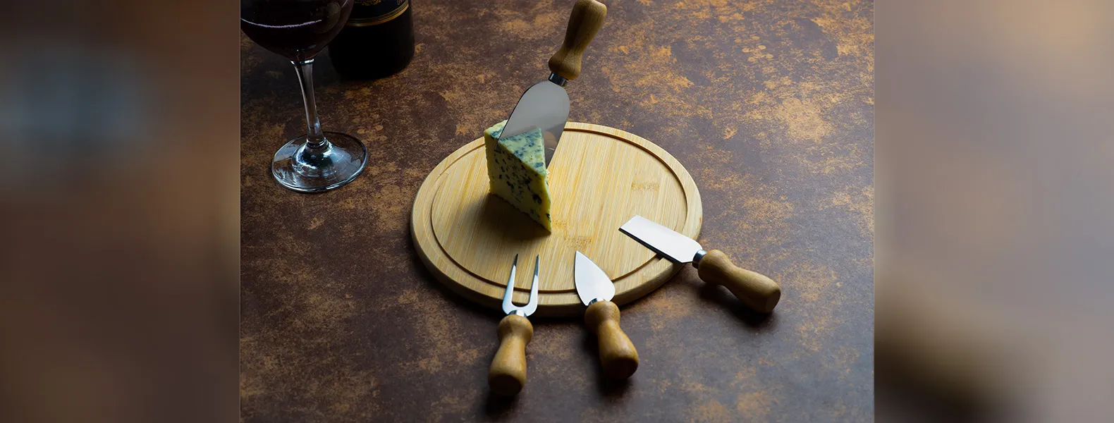 Kit para queijo. Conta com tábua redonda em bambu; duas facas, uma espátula e um garfo para queijos. Tábua confeccionada com tripla camada invertida, para dar maior durabilidade e não deformar com o passar do tempo.