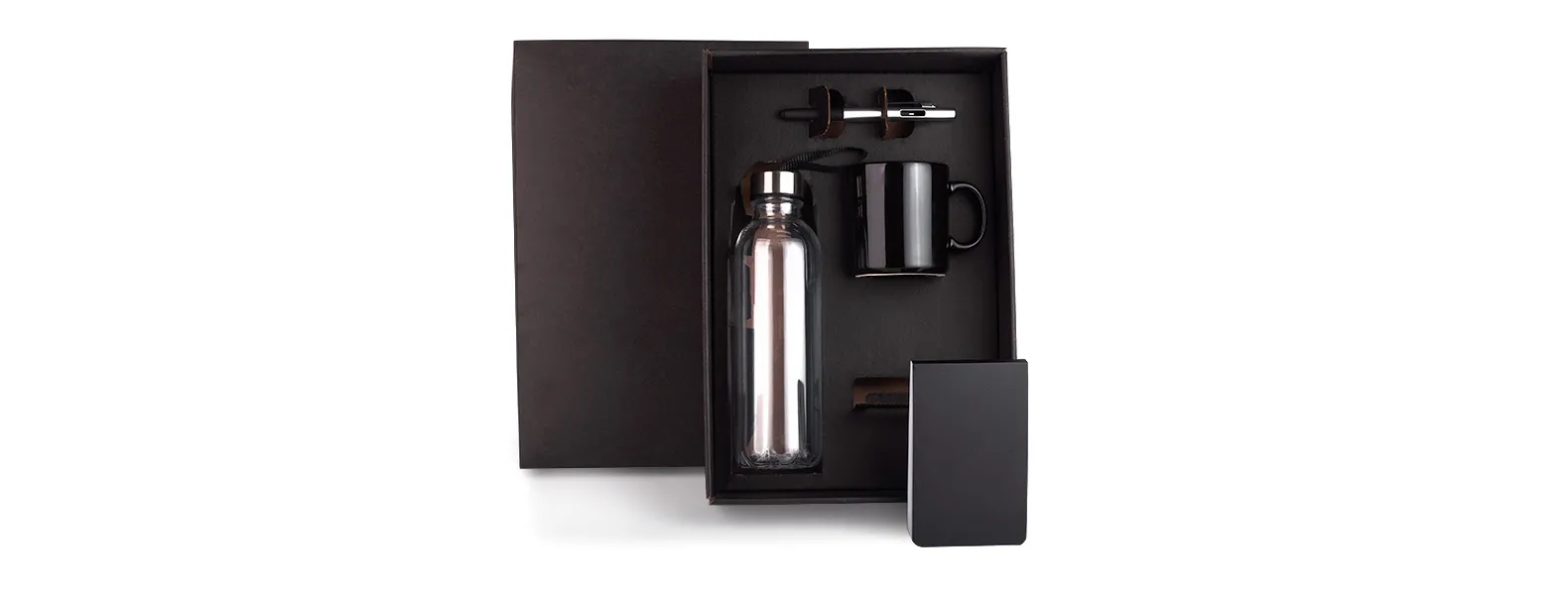 Esse kit conta com garrafa transparente em PET; caneca em cerâmica preta; bloco para anotações preto e caneta esferográfica em ABS prata.