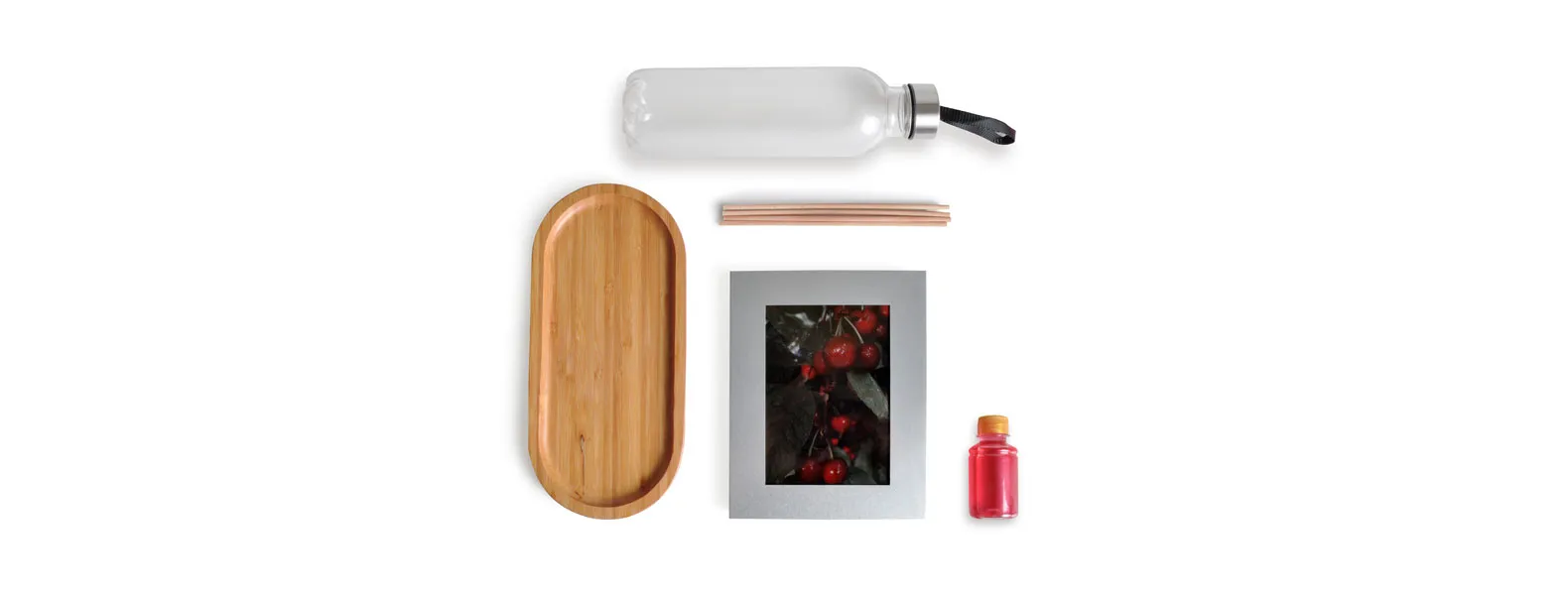 Kit bandeja, aromatizador e acessórios. Composto por bandeja oval em bambu; garrafa transparente em PET; porta-retrato em alumínio; aromatizador de ambiente com fragrância de cereja e avelã.