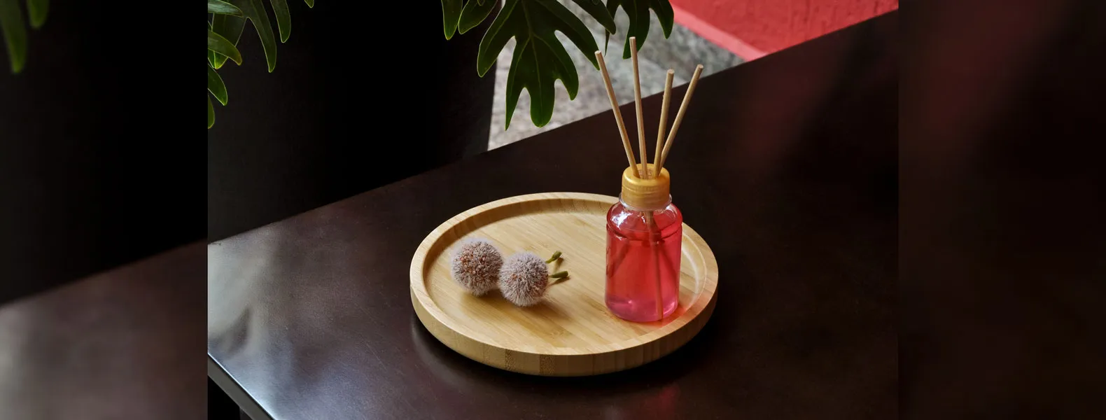Kit para bandeja e aromatizador. Conta com bandeja redonda em bambu e aromatizador de ambiente com fragrância de cereja e avelã.