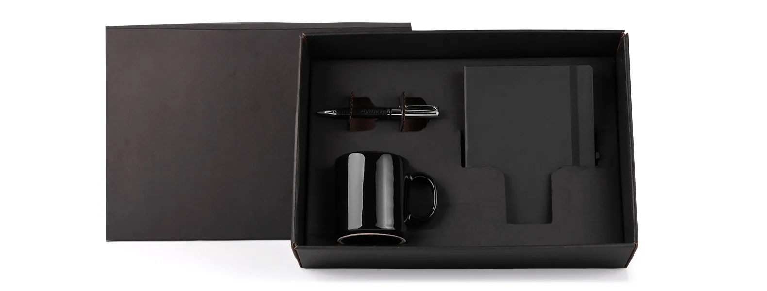 Kit composto por caneca em cerâmica preta; caderno para anotações preto com capa dura e caneta confeccionada em metal cromado brilhante com corpo revestido em material sintético preto texturizado.