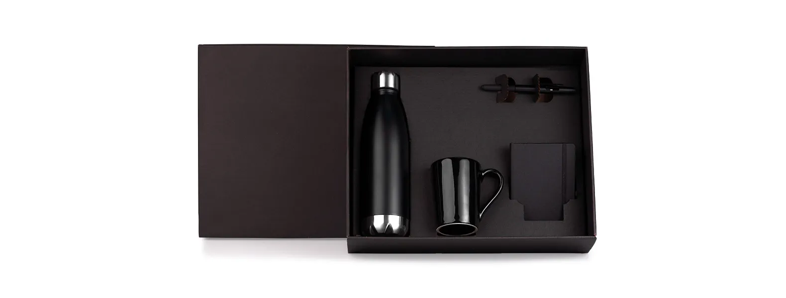 Kit garrafa e acessórios. Composto por garrafa em aço Inox preta com tampa rosqueável; caneca em cerâmica preta; caderno para anotações preto com capa dura e caneta esferográfica em ABS preta.