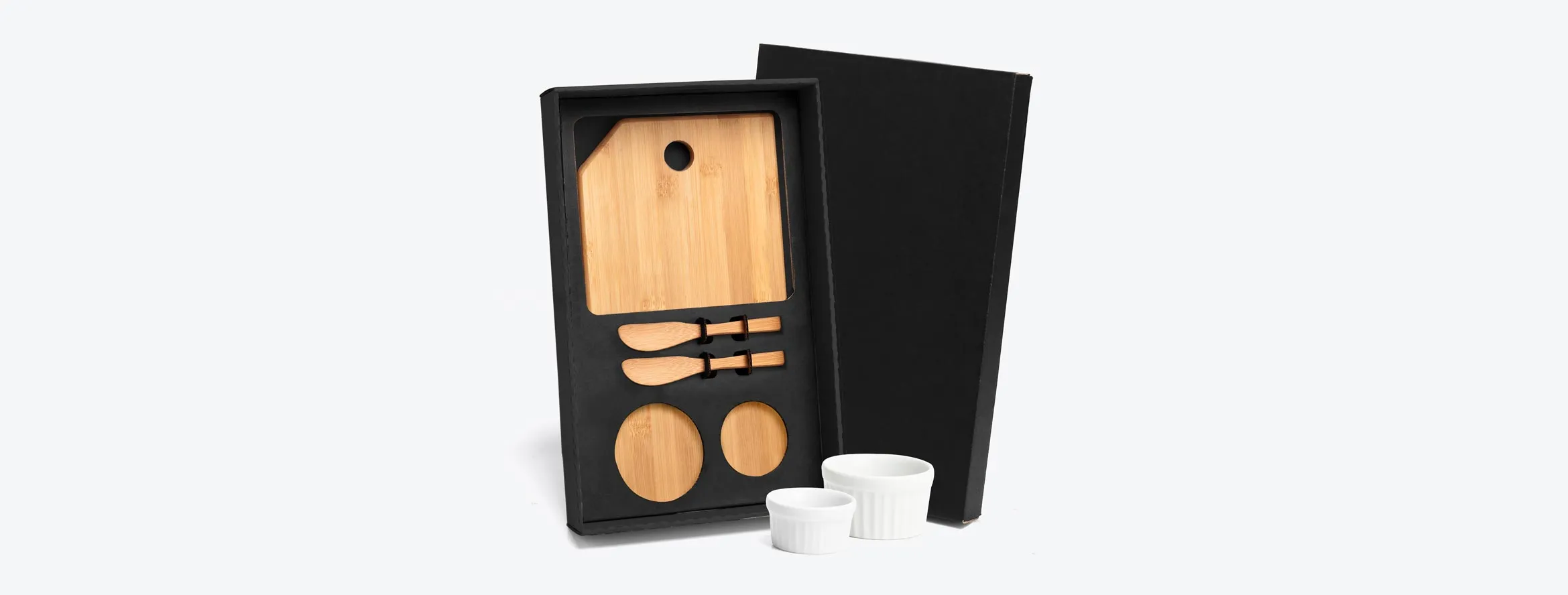 Kit para petisco contendo tábua com furo e duas espátulas 14cm em bambu; Dois ramekins, um pequeno e um mini em porcelana. Estão perfeitamente acomodados em uma caixa para presentear.