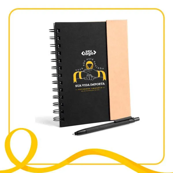 Caderno espiral preto/bege com capa e caneta em Papelão Reciclado rígido, 70 folhas pautadas. Fechamento através de imã na aba. 6 blocos auto colantes, com 25 folhas cada. Caneta com ponta touch e carga esferográfica preta, acionada por click.