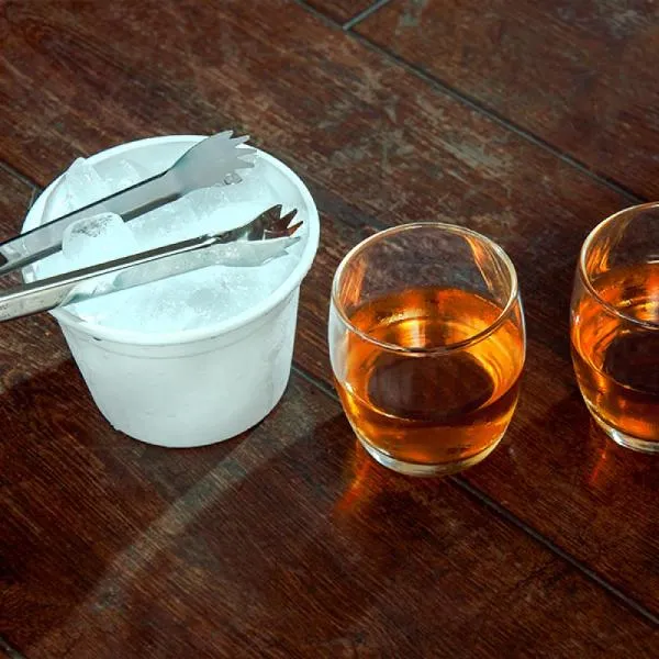 Kit para whisky. Conta com dois copos para whisky em vidro, pegador para gelo em aço inox e balde para gelo 750 ml em alumínio branco.