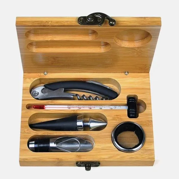 Kit para vinho. Composto por cinco acessórios para vinho em metal e inox, sendo um anel corta-gotas, um funil direcionador com tampa e tampão, ambos com detalhes emborrachados para melhor fixação na garrafa, um termômetro e um abridor saca-rolhas modelo sommelier de alavanca simples com três funções acomodados em um estojo em bambu.