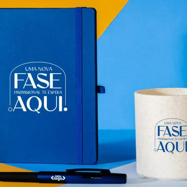 Kit composto por caneca em fibra de bambu/PP; caderno para anotações azul com capa dura e caneta esferográfica em ABS azul.