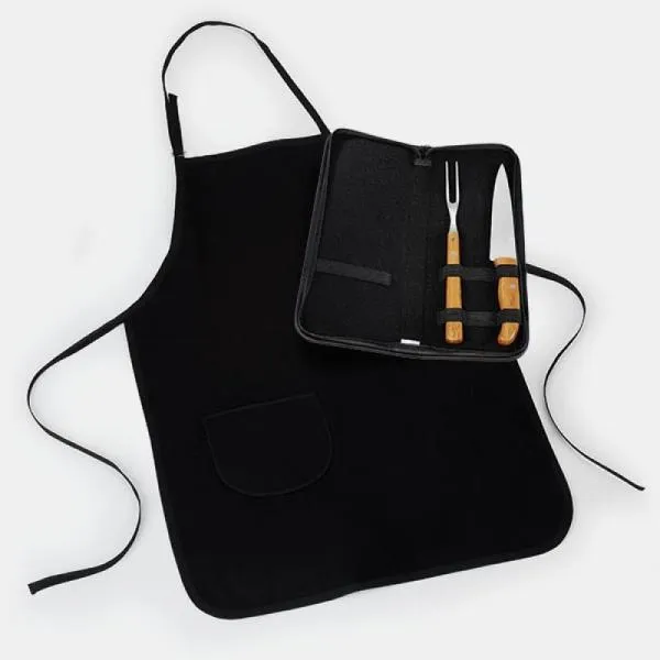 Kit com um avental confeccionado em Brim preto com bolso frontal, tiras na cintura e pescoço com regulagem de altura, uma faca 7” e um garfo trinchante, ambos com cabos em bambu e lâminas em aço Inox com rebites resistentes. Estão organizados em estojo com fita elástica preta.