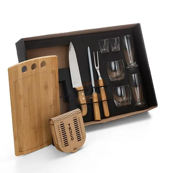 Kit para Churrasco, Drinks e Truco. Composto por tábua com três furos em Bambu; garfo em Bambu/Inox; faca 8; dois copos de Cerveja, dois copos de Whisky e dois copinhos de dose em vidro; caixa para truco com jogo de cartas, marcador de tentos e jogos em MDF. Como cortesia, na faca 8 fazemos uma gravação com os cortes do boi.